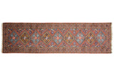 A vintage Ardebil runner's geometric design of rust, blue, and gold diamond medallions.