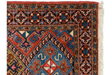 Corner of Persian Ardebil runner showing pinwheel floral border and serpent design motif.