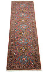 Angled view of a vintage Ardebil runner highlighting its full length and geometric diamond medallions.