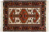 Close-up of ivory fringe, rust border, and stylized motifs on vintage Indian rug.