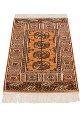Angled perspective of a vintage Bokhara rug with geometric guls on a deep gold field.