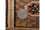 Close view of the vintage Indian rug's full wool pile and hand-knotted weave, with a coin for scale.