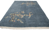 Denim blue vintage Indian Art Deco carpet detail: blush floral spray and carved border.
