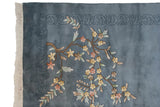 Denim blue vintage Art Deco rug corner, featuring floral spray, carved border, ivory fringe.