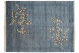 Denim blue vintage Art Deco carpet corner, with ivory fringe, carved border, and blush floral motifs.