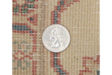 Hand-knotted pile texture in antique ivory, dusty blush, and seafoam green, with a quarter.