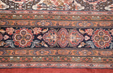 Detail of vintage Indian carpet border with stylized vinery in navy, brick red, and peach.