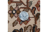 Detail of vintage Indian carpet pile with quarter, revealing rococo-inspired vinery in ivory, brown, red.