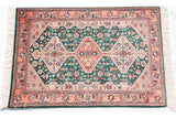 Indian Afshar rug corner with forest green field, cantaloupe melon motif, and ivory fringe.