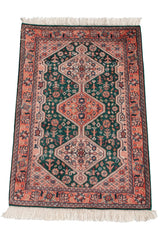 Intricate triple diamond medallions and floral details on a forest green vintage Afshar rug.