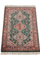 Vintage Indian Afshar design rug detail: forest green field, cantaloupe border, ivory fringe.