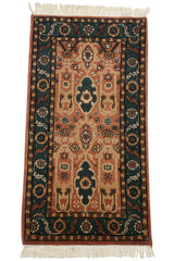 Close-up of vintage Indian rug's left border, copper field, green serrated leaf pattern.