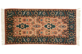 Copper field with green elongated floral cartouches and serrated leaf border.