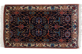 Vintage Indian Bijar design rug with a navy blue field, floral arabesques, and a cream palmette border.