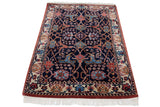 High-angle view of a vintage Indian Bijar rug's plush navy pile and intricate floral design.