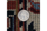 A coin for scale on the vintage rug's full, like-new hand-knotted wool pile.