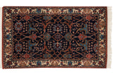 Intact side cord selvage and full pile of the vintage rug's floral palmette border and navy field.