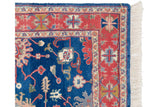 Vintage Indian Bijar design rug corner with terracotta border, sapphire blue field, and fringe.
