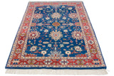 Corner of vintage Bijar rug: sapphire blue field with palmettes, terracotta border, white fringe.