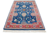 Crisp white fringe and geometric cherry red border of the vintage Indian rug.