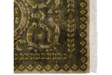 Embossed olive green Savonnerie rug corner with plant and blossom borders, and fringe.