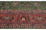 Curvilinear forest green field and ornate brick red border of a vintage Indian carpet.