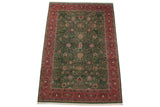 Vintage Indian Meshed rug corner, showing forest green field with blossoms and brick red border.