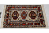 Vintage Indian Caucasian rug's detailed ivory field with geometric florals and multi-cartouche border.