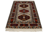 Indian Caucasian design rug with rust, navy multi-cartouche border and ivory geometric field.