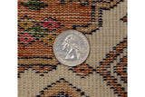 Close-up of vintage Indian rug's dense weave, geometric ivory, rust, navy patterns, quarter for scale.
