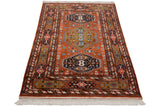 Vintage Indian Caucasian rug corner, rust field, multi-cartouche border, white fringe.