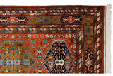 Corner of vintage Indian Caucasian rug, rust field, geometric borders, white fringe.