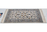 Vintage Indian Isfahan rug close-up: ivory field, navy border, palmettes, delicate vines, and fringe.