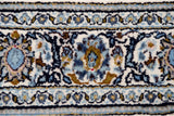 Close-up of the Isfahan rug's ivory, navy, and bronze palmette and vine design.
