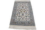 Ivory fringe, full pile, and intricate floral border with navy, silver, and bronze palmettes.
