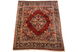 Angled view of the vintage Sarouk carpet highlighting its diamond medallion and corner spandrels.