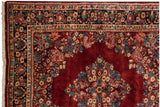 Dense floral bouquets fill the corner spandrel and navy border of a vintage Persian Sarouk.