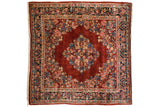 Collector's vintage Persian Sarouk carpet featuring balanced floral motifs in gem-tones on a ruby red field.