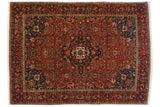 Vintage Bakhtiari carpet with a central medallion, dense paisley field in madder red, and sapphire blue corner spandrels.