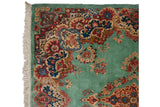 Intact ivory fringe and full pile on the floral corner of a vintage ocean green Kerman rug.