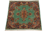 Full pile of a vintage Kerman rug with a floral medallion, shown from an angled perspective.