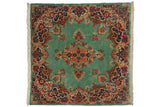 Vintage Persian Kerman square rug with a scrolling red and blue medallion on an ocean green open field.
