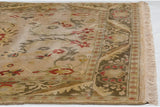 Vintage Indian Arts and Crafts rug corner showcasing floral border, serrated leaves, and cream fringe.