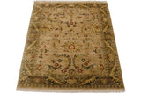 Corner view of vintage Indian Arts and Crafts carpet: beige field with olive leaves, red palmettes.
