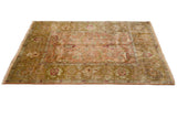 The high sheen pile of a vintage Agra carpet with sprawling leaves in dusty rose and ochre green.