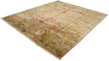 Angled perspective of the vintage Agra carpet highlighting the sheen on its dusty rose and ochre green pile.