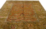 Oversized palmettes and lotus flowers in the wide, ochre green border of a vintage Agra carpet.