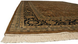 Corner view of a vintage Indian rug with a plush pile, navy floral border, and clean ivory fringe.
