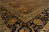 Angled view of the vintage carpet's corner, detailing the navy blue floral border and copper brown field.