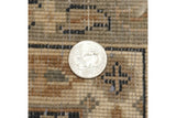 A coin for scale on the even, hand-knotted pile of a vintage Indian Tabriz design rug.